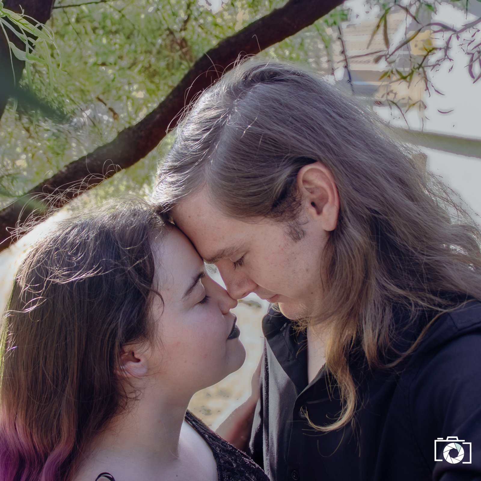 Couple enjoying a tender moment outdoors, showcasing professional photography services and creative portrait sessions.